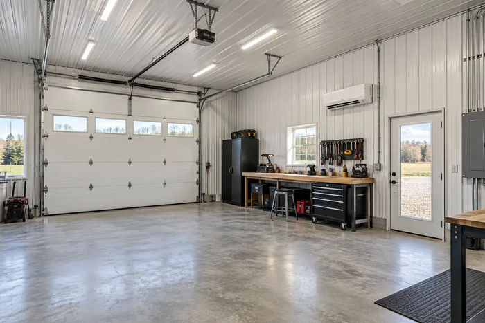 Finished pole-barn shop with liner panels, lighting, and organized electrical service.